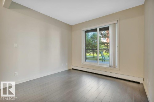 Unfurnished room with a baseboard heating unit and wood finished floors - 140 308 Ambleside Link, Edmonton, AB - Indoor Photo Showing Other Room