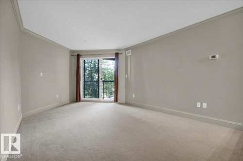 Carpeted empty room with ornamental molding and a textured ceiling - 226 13111 140 Avenue, Edmonton, AB - Indoor Photo Showing Other Room
