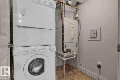 Laundry room featuring stacked washing machine and dryer and heating unit - 226 13111 140 Avenue, Edmonton, AB - Indoor Photo Showing Laundry Room