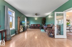 Living room featuring wood finished floors and ceiling fan - 