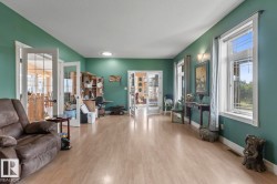 Living area with light wood-style floors, a chandelier, and french doors - 
