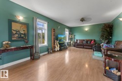 Living room with light wood-style flooring and a ceiling fan - 