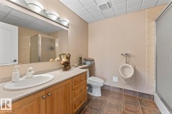 Bathroom featuring a shower stall, vanity, dark tile patterned flooring, and a drop ceiling - 
