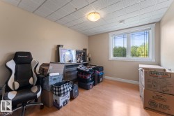 Bedroom featuring plenty of natural light, light wood-style flooring, and a drop ceiling - 