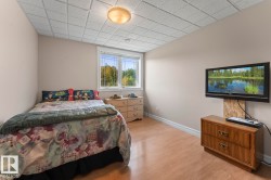 Bedroom featuring light wood-style flooring and a paneled ceiling - 