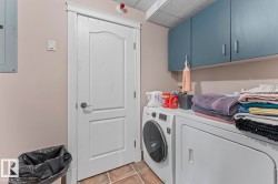 Laundry room featuring tile patterned floors, cabinet space, electric panel, and washer and dryer - 