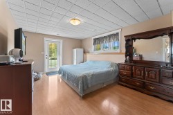Bedroom with access to outside, multiple windows, light wood-style floors, and a drop ceiling - 