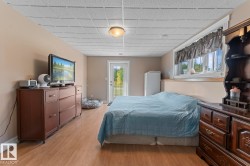 Bedroom with light wood-style flooring, access to exterior, and a drop ceiling - 