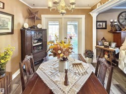 Dining space featuring a chandelier, crown molding, and wood finished floors - 