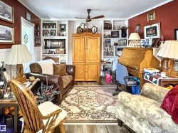Sitting room with wood finished floors, ornamental molding, ceiling fan, a textured ceiling, and built in shelves - 
