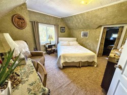 Carpeted bedroom with a textured ceiling, lofted ceiling, a textured wall, and crown molding - 