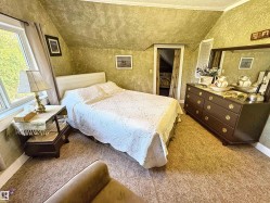 Bedroom with lofted ceiling and light colored carpet - 