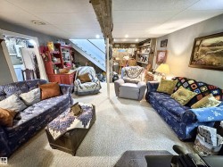 Living area featuring carpet floors, a drop ceiling, and stairway - 