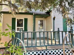 Entrance to property with a wooden deck and roof with shingles - 