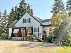 Rear view of property with a deck, a shingled roof, a chimney, and a yard - 