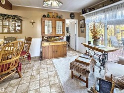 Dining room featuring a wainscoted wall, ornamental molding, and light stone finish floors - 