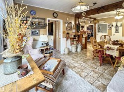 Living area featuring ornamental molding, wainscoting, and a ceiling fan - 