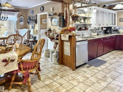 Kitchen featuring hanging light fixtures, stainless steel dishwasher, tasteful backsplash, crown molding, and a chandelier - 