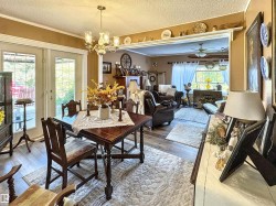 Dining room featuring a textured ceiling, wood finished floors, a chandelier, and a ceiling fan - 