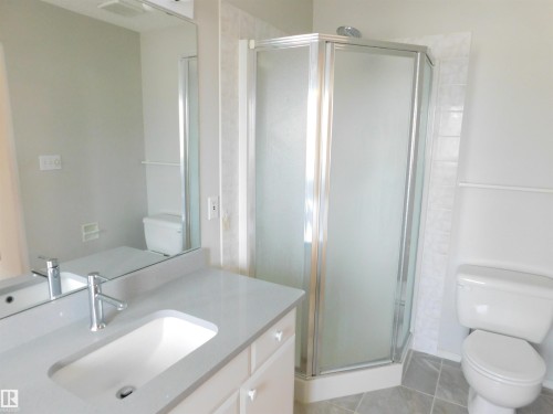Full bath featuring a stall shower, vanity, and light tile patterned flooring - 26 1295 Carter Crest Road, Edmonton, AB - Indoor Photo Showing Bathroom