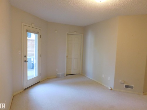 Spare room featuring a textured ceiling and light colored carpet - 26 1295 Carter Crest Road, Edmonton, AB - Indoor Photo Showing Other Room