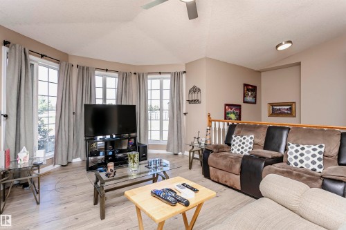 Living room with lofted ceiling, a textured ceiling, healthy amount of natural light, light wood-style floors, and a ceiling fan - 8 Lafond Drive, Tofield, AB - Indoor Photo Showing Living Room