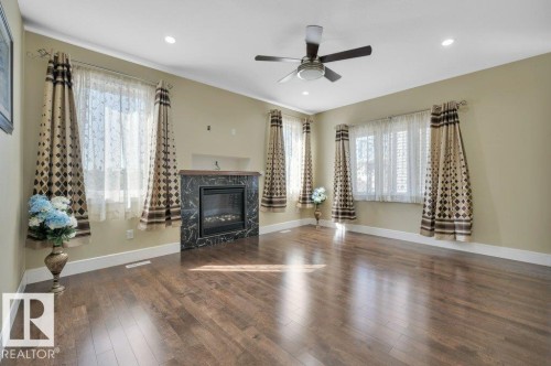 Living area featuring dark wood-style flooring, a fireplace, recessed lighting, and ceiling fan - 6221 167A Avenue, Edmonton, AB - Indoor Photo Showing Living Room With Fireplace