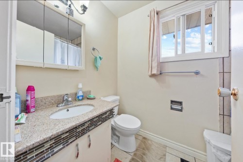 Full bathroom featuring vanity, light tile patterned flooring, and curtained shower - 285 Harrison Drive, Edmonton, AB - Indoor Photo Showing Bathroom
