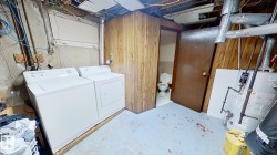Laundry area featuring independent washer and dryer, gas water heater, and wooden walls - 