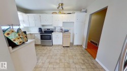 Kitchen featuring light countertops, stainless steel range with electric stovetop, white cabinetry, and under cabinet range hood - 
