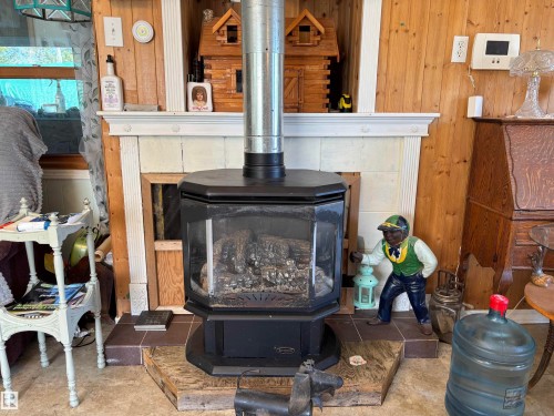Detailed view of wood walls and a wood stove - 140 Russel Drive, Rural St. Paul County, AB - Indoor Photo Showing Living Room With Fireplace