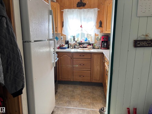 Kitchen with freestanding refrigerator, light countertops, brown cabinets, and stainless steel range oven - 140 Russel Drive, Rural St. Paul County, AB - Indoor Photo Showing Kitchen