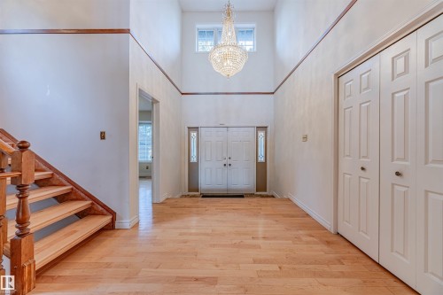Foyer entrance featuring light wood-style flooring, a high ceiling, a chandelier, and stairway - 1602 106 Street, Edmonton, AB - Indoor Photo Showing Other Room