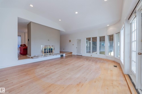 Unfurnished living room featuring recessed lighting, light wood finished floors, a glass covered fireplace, and lofted ceiling - 1602 106 Street, Edmonton, AB - Indoor Photo Showing Other Room