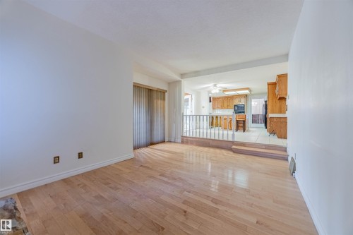 Unfurnished living room with light wood-style flooring and a ceiling fan - 1602 106 Street, Edmonton, AB - Indoor Photo Showing Other Room