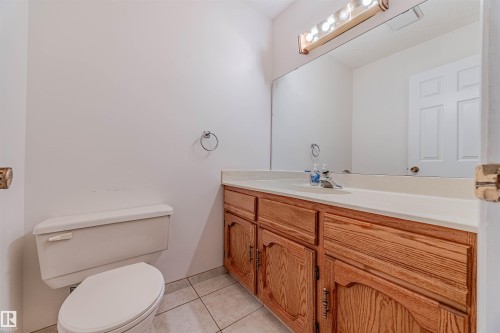 Half bath with light tile patterned flooring and vanity - 1602 106 Street, Edmonton, AB - Indoor Photo Showing Bathroom