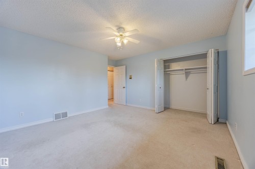 Unfurnished bedroom with light colored carpet, a ceiling fan, a textured ceiling, and a closet - 1602 106 Street, Edmonton, AB - Indoor Photo Showing Other Room