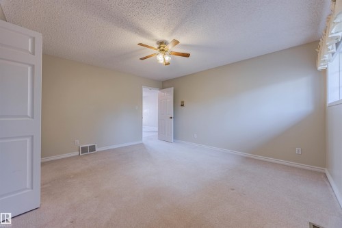 Spare room featuring light colored carpet, ceiling fan, and a textured ceiling - 1602 106 Street, Edmonton, AB - Indoor Photo Showing Other Room