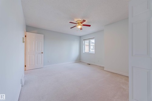 Empty room featuring light carpet, a textured ceiling, and ceiling fan - 1602 106 Street, Edmonton, AB - Indoor Photo Showing Other Room