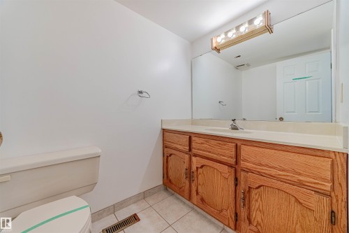 Half bath with light tile patterned floors and vanity - 1602 106 Street, Edmonton, AB - Indoor Photo Showing Bathroom