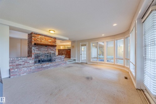 Unfurnished living room with carpet floors, a fireplace, recessed lighting, and a textured ceiling - 1602 106 Street, Edmonton, AB - Indoor With Fireplace