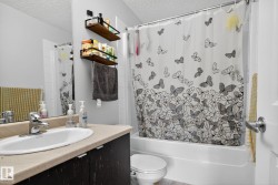 Full bath featuring shower / bath combo with shower curtain, vanity, and a textured ceiling - 