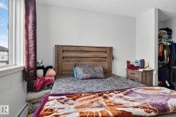 Bedroom featuring a baseboard heating unit, a textured ceiling, and a walk in closet - 
