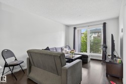 Living area featuring dark wood-style floors and a textured ceiling - 