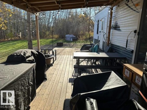 Deck with area for grilling, outdoor dining area, and a yard - #544 12002 Twp Rd 605A, Rural St. Paul County, AB 