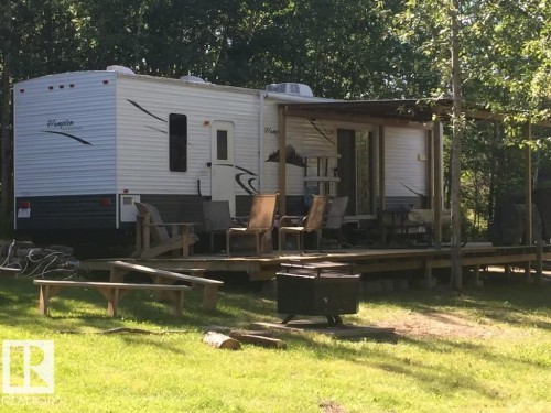 Back of house featuring a yard and a wooden deck - #544 12002 Twp Rd 605A, Rural St. Paul County, AB 