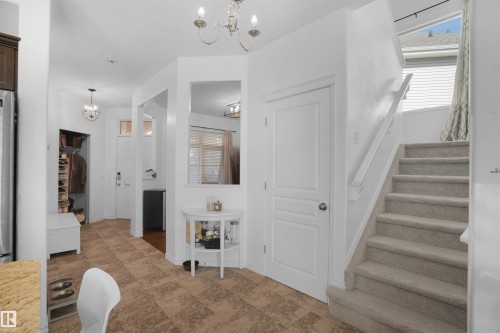 Staircase featuring a chandelier and healthy amount of natural light - 20705 56A Avenue, Edmonton, AB - Indoor Photo Showing Other Room