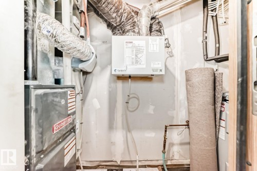 Utility area featuring a furnace system, exposed ductwork, and wall-mounted mechanical unit - 68 5 Rondeau Drive, St. Albert, AB - Indoor Photo Showing Other Room