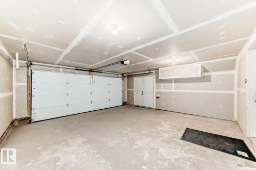 Spacious garage featuring a concrete floor, overhead lighting, and an automatic garage door opener - 68 5 Rondeau Drive, St. Albert, AB - Indoor Photo Showing Garage