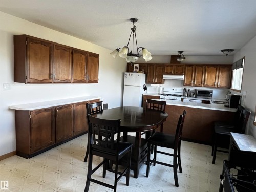 Dining area featuring light flooring and a chandelier - 74038 Birch Avenue, Widewater, AB - Indoor Photo Showing Kitchen